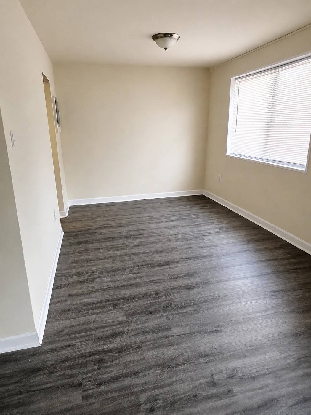 A renovated living room with wood-style plank flooring